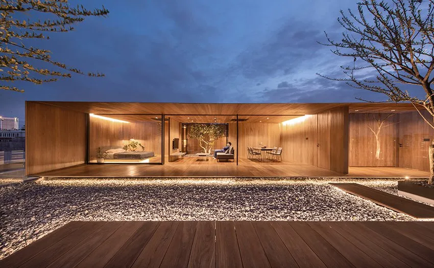 Modern residential interior decorated primarily with wooden elements and featuring a central tree。