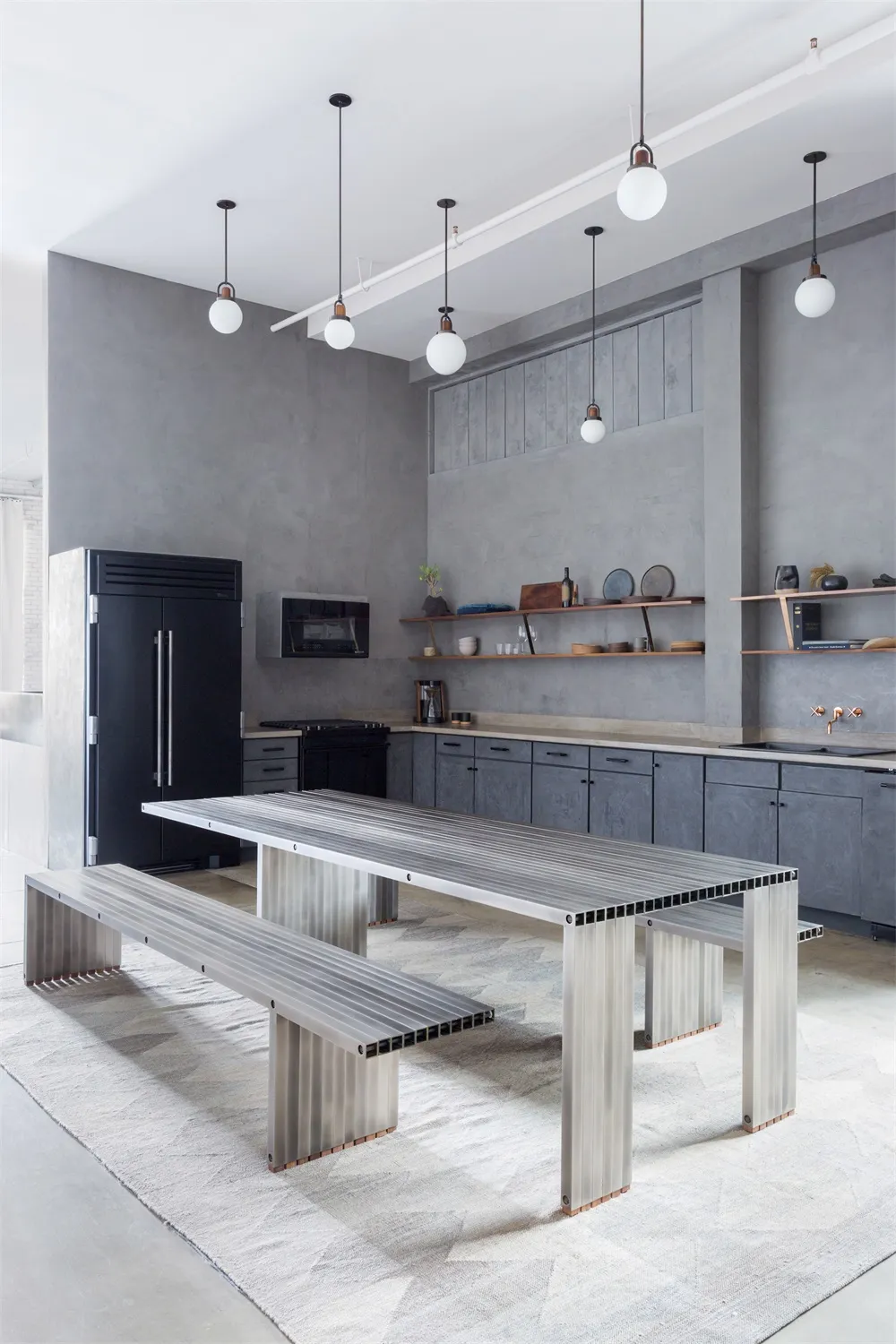 A modern industrial kitchen with metal and concrete elements.