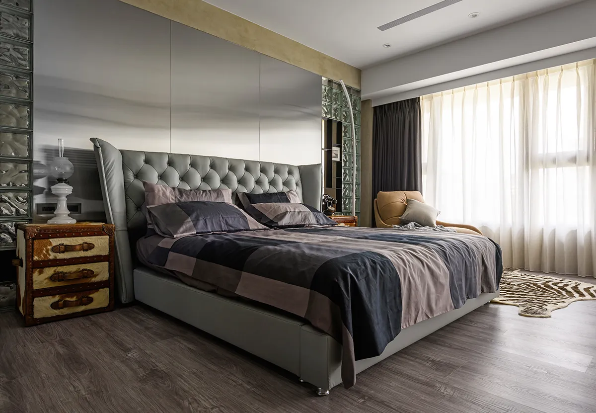 Modern bedroom with a leather upholstered bed, geometric rug, and natural light