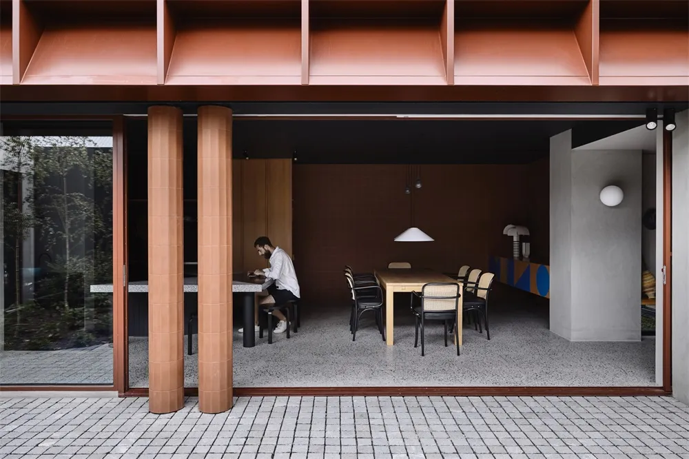 A modern dining room featuring wood, concrete, and glass materials.