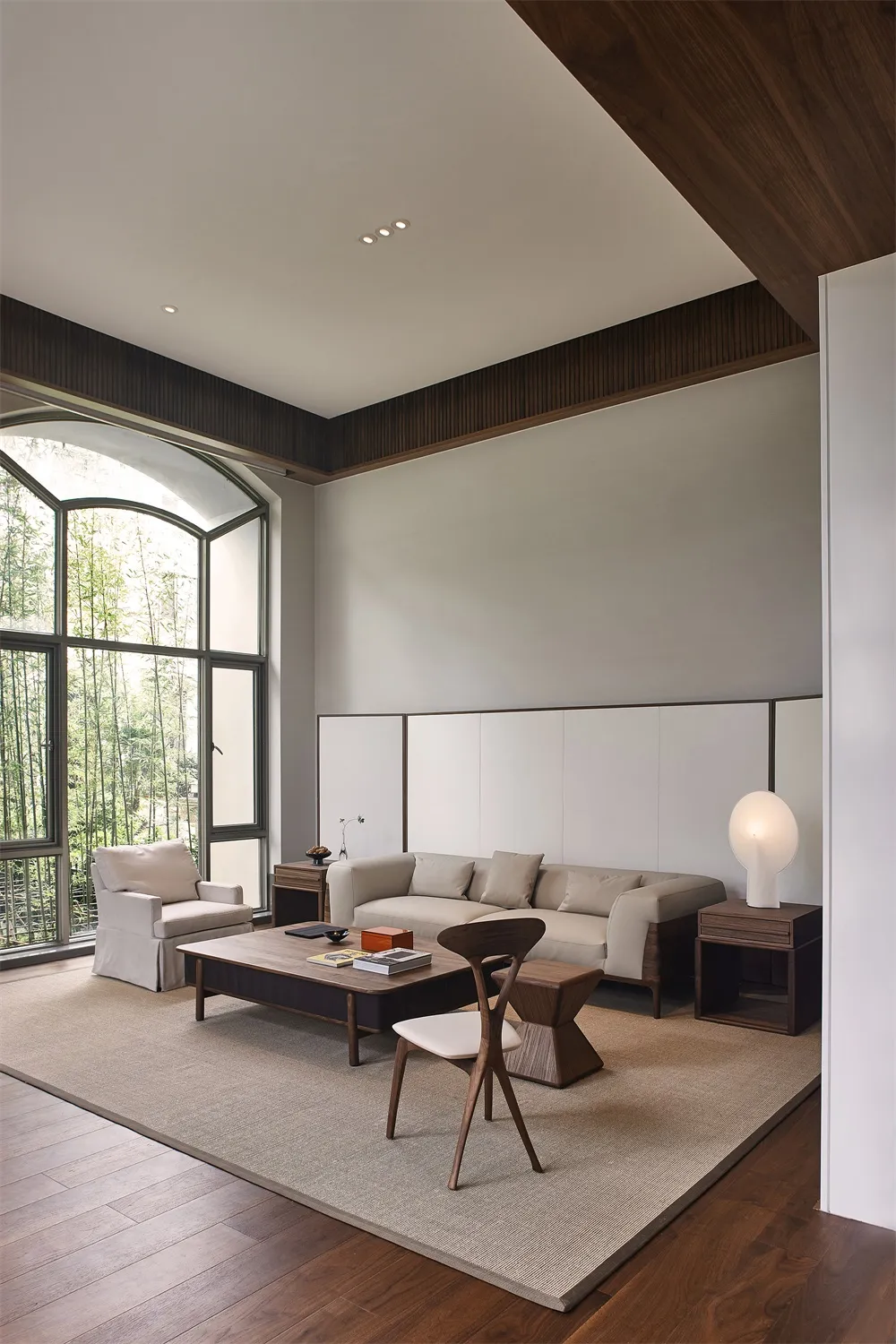 Modern minimalist living room featuring a sofa, armchair, coffee table, and floor lamp.