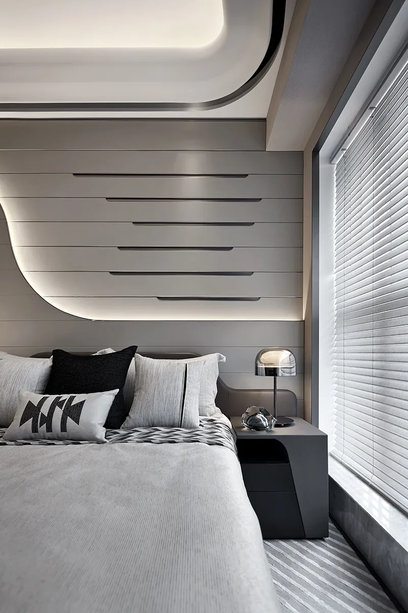 Modern minimalist bedroom with white walls, bed, and nightstand.