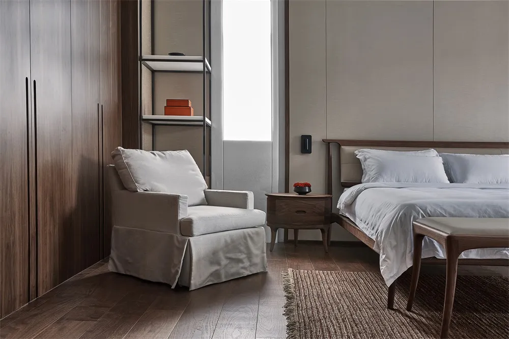 Modern minimalist bedroom featuring wood furniture, white bedding, and a soft armchair in a serene environment.