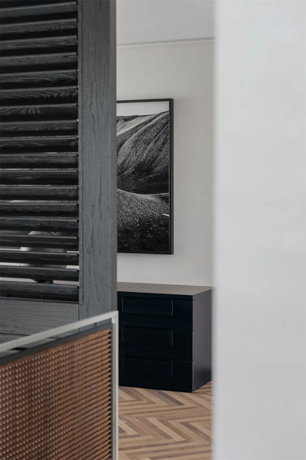 Modern bedroom featuring black and white abstract art hanging above a minimalist dresser.