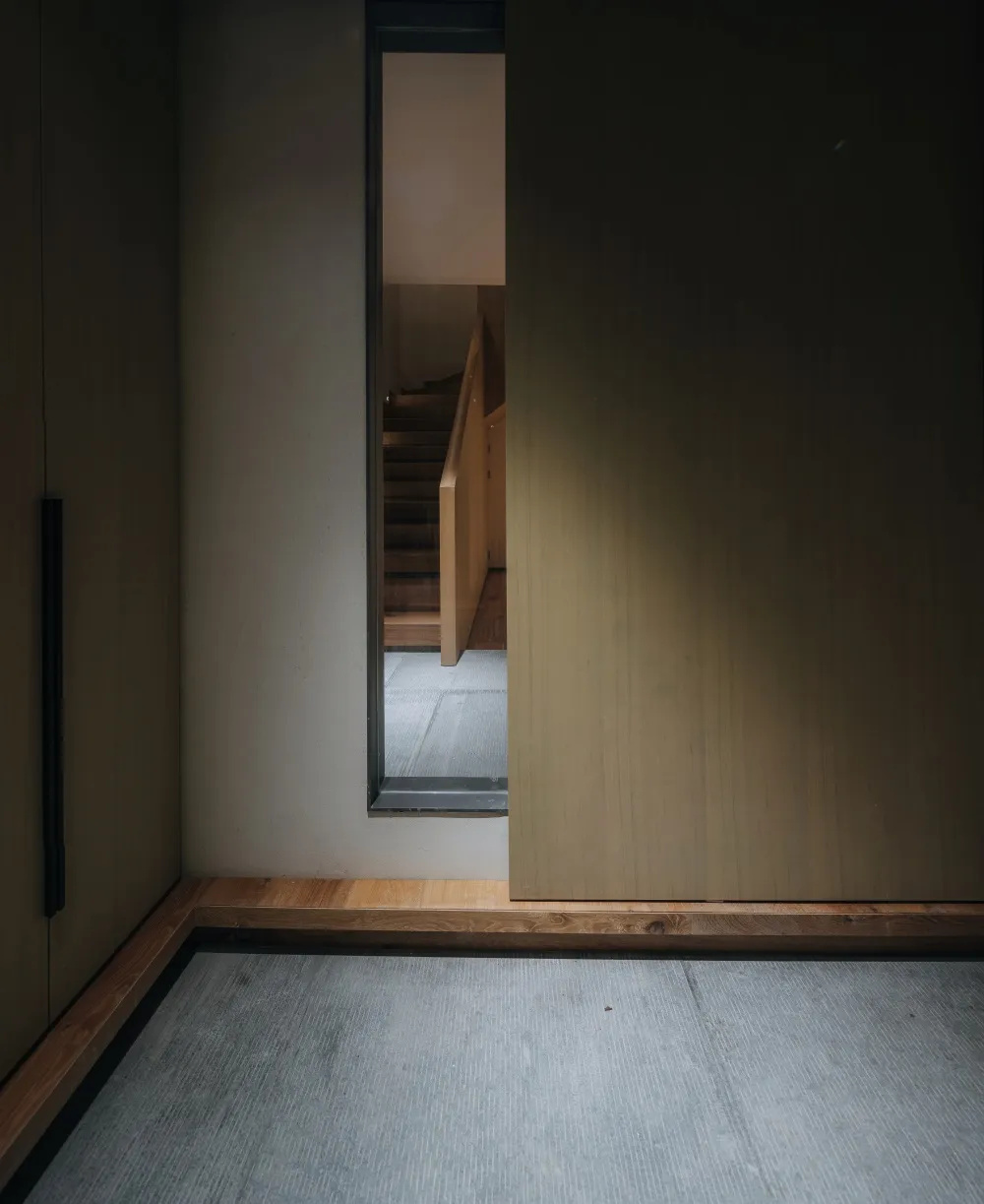 A view of a modern staircase featuring wooden paneling, seen from the top.
