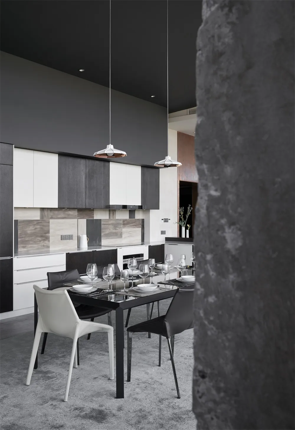 Modern interior design featuring metallic black and white kitchen and dining room with pendant lights and sleek furniture.