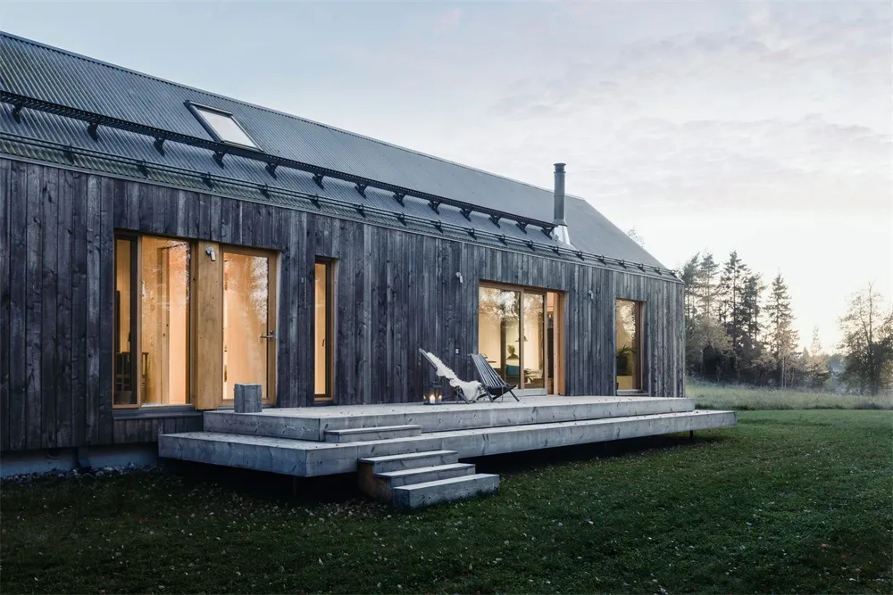 Modern exterior of a house with wooden siding and large windows.