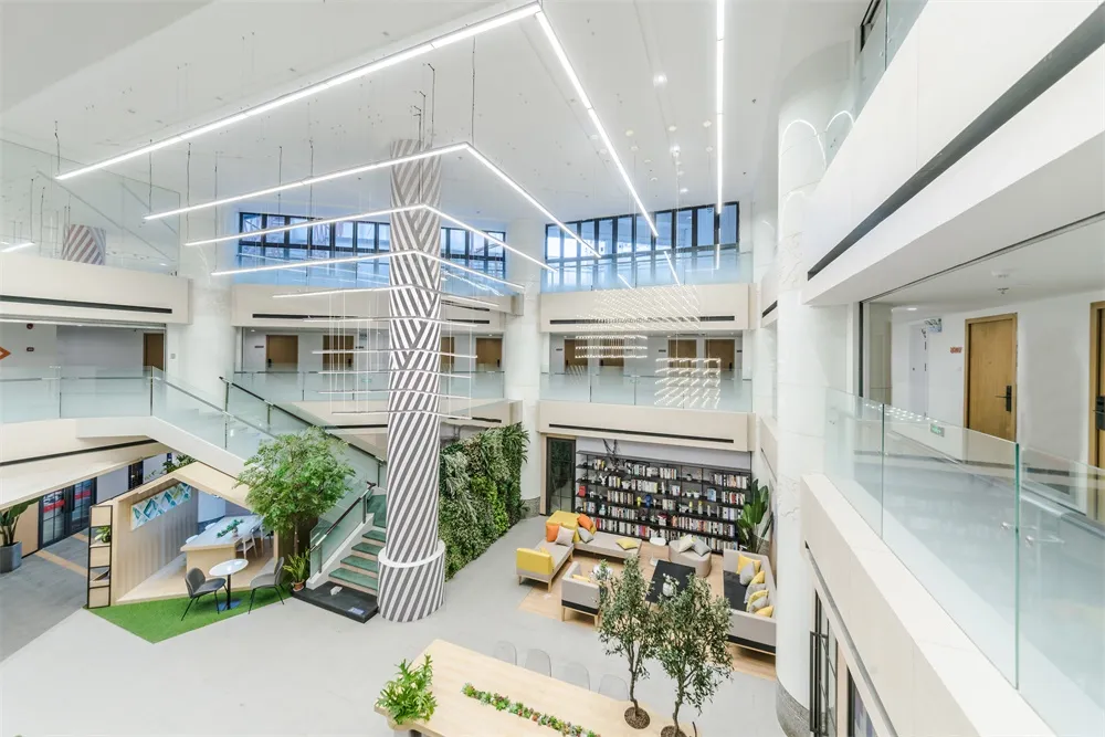 A modern office space with white materials and a central water fountain.
