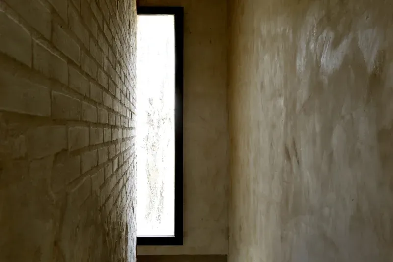 Minimalist corridor with concrete and brick walls and a bright window