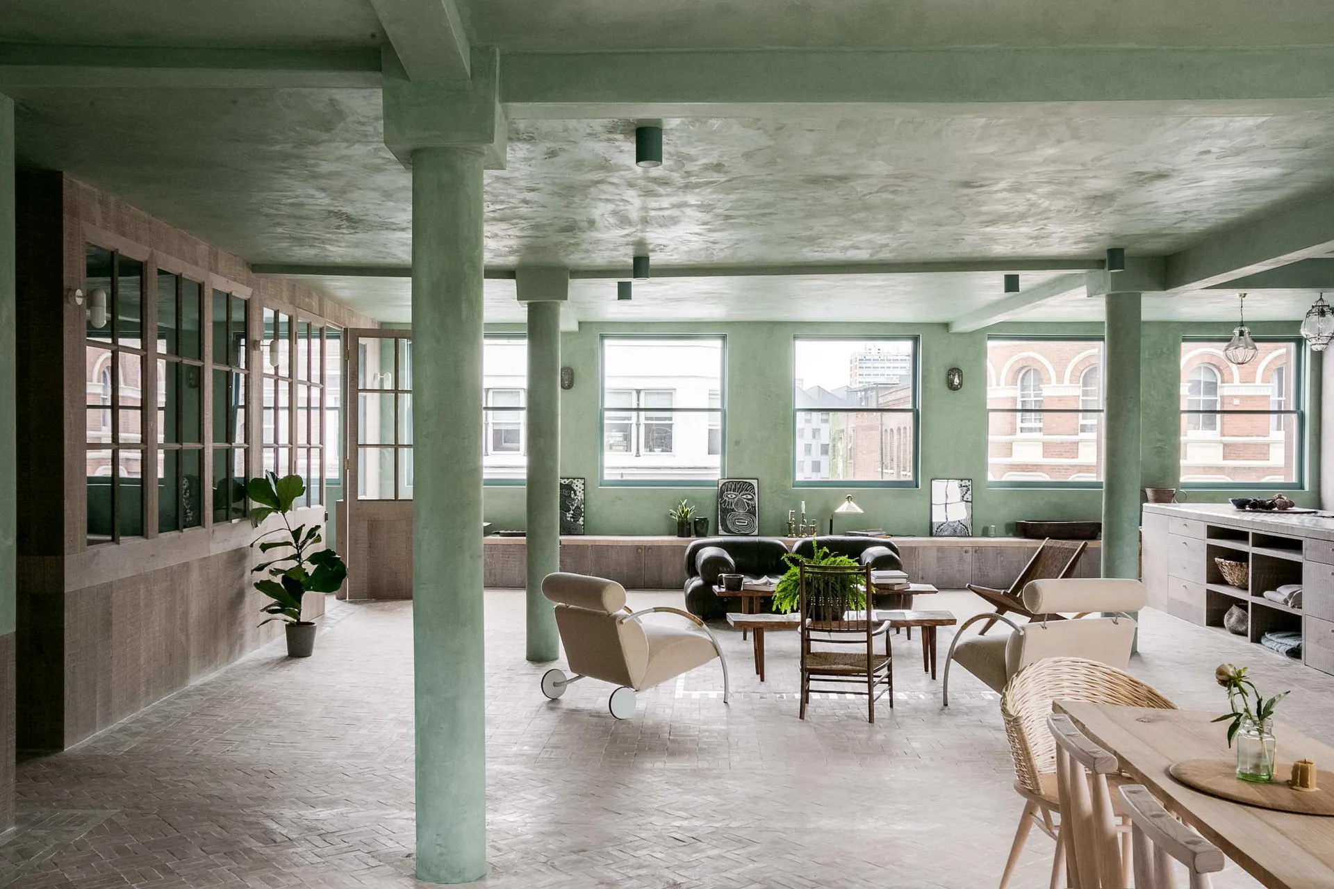 A modern industrial living room with a concrete ceiling, wooden furniture, and glass windows.