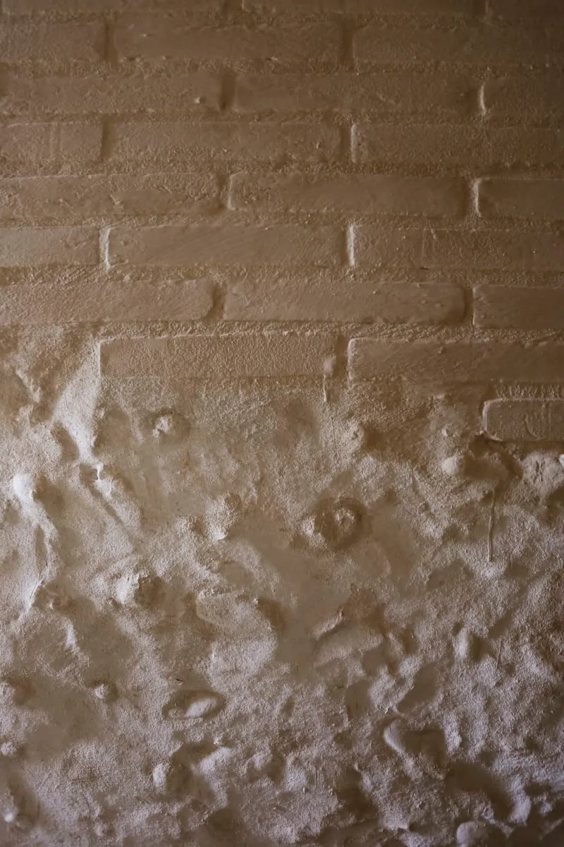 Industrial-style wall featuring a brick pattern painted with a textured finish.