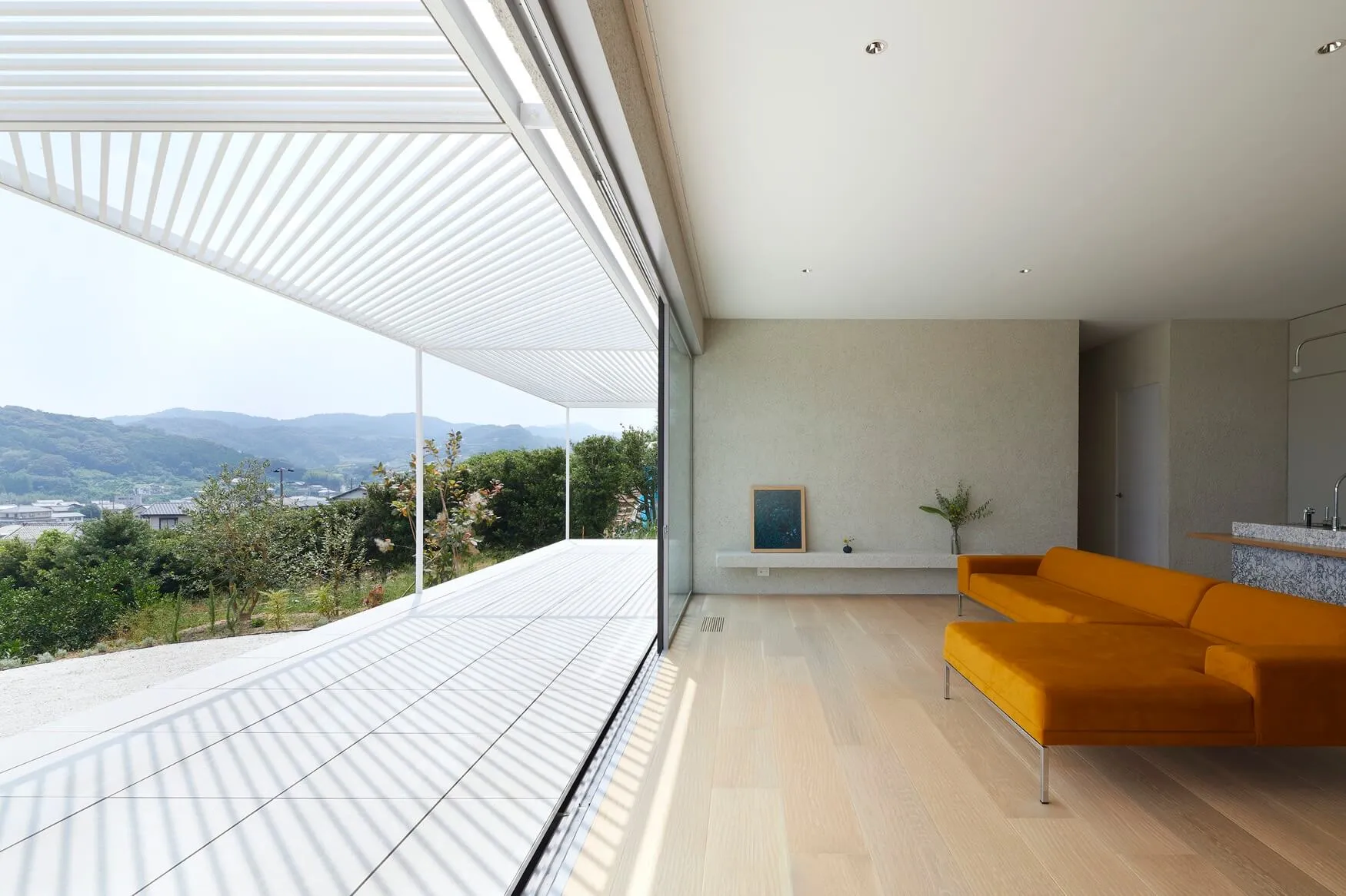 Modern living room featuring a concrete floor and large windows with a view of the mountains.