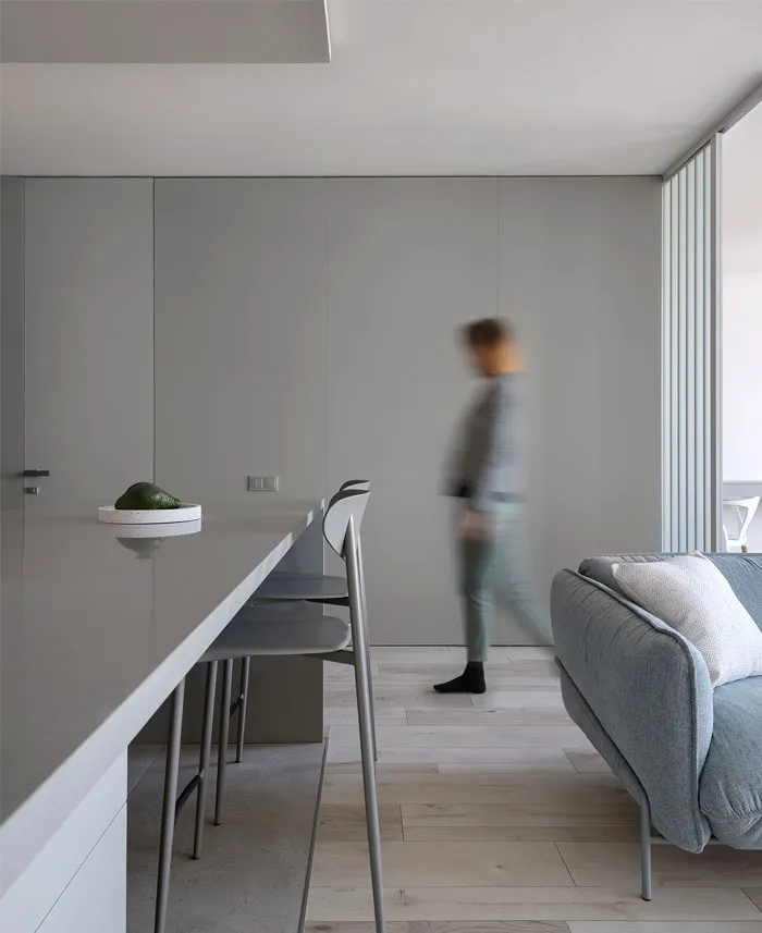 A modern minimalist living room with a concrete floor and wall.