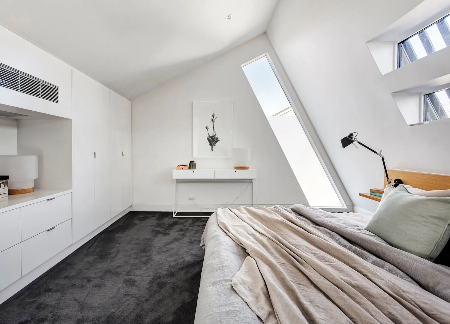 Modern white bedroom with concrete furniture and grey carpet