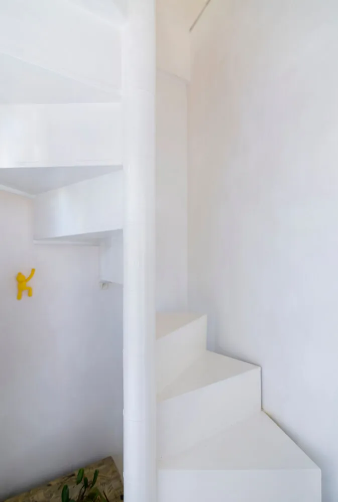 White minimalist staircase with white walls and railings.