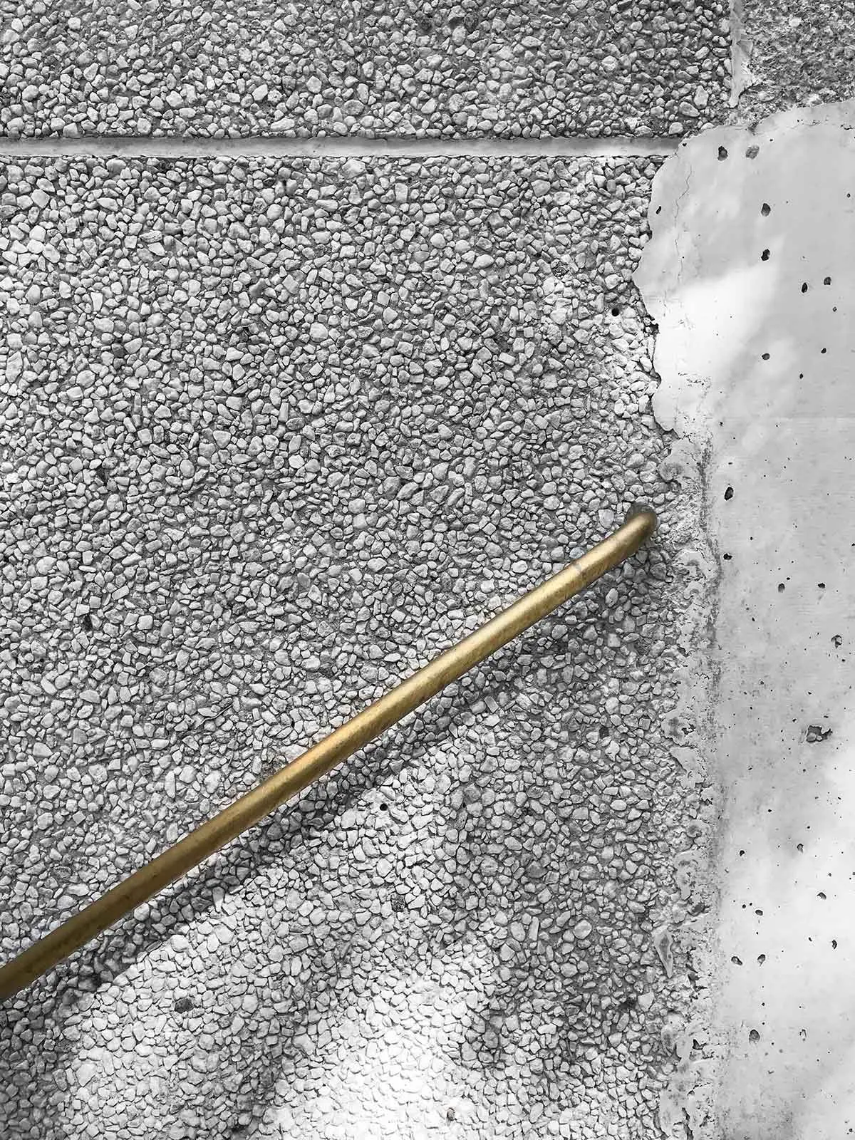A brass pipe embedded in a concrete floor.