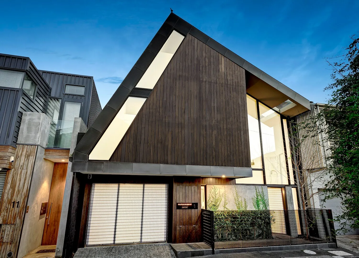 Modern house with dark wood facade and large windows.