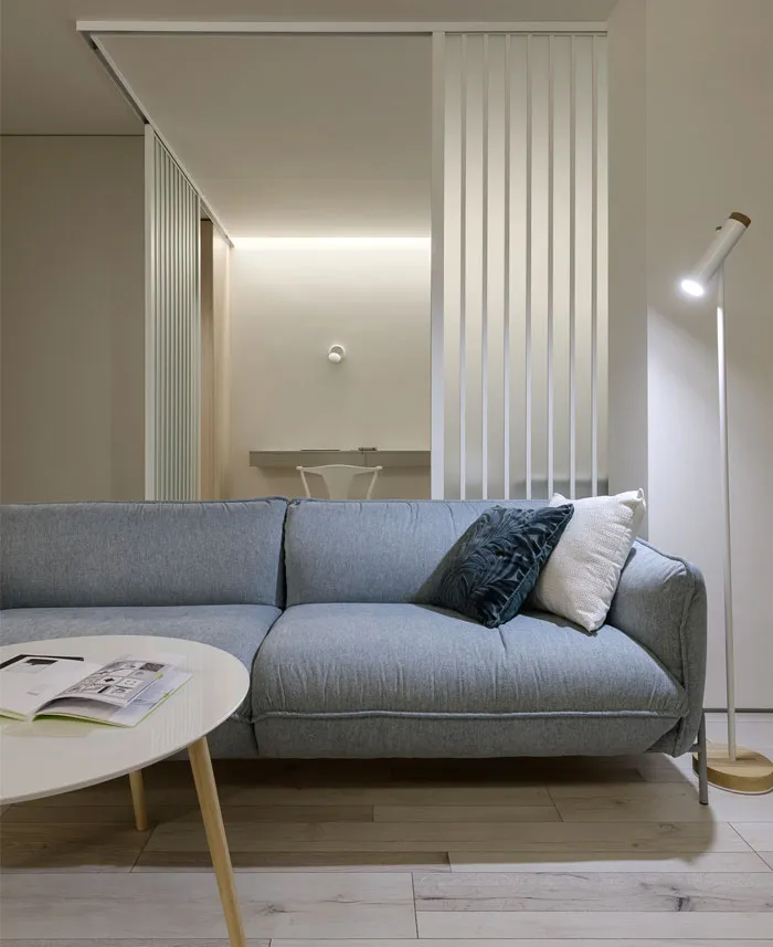 A modern living room with a neutral-toned sofa, round coffee table, and minimalist design.