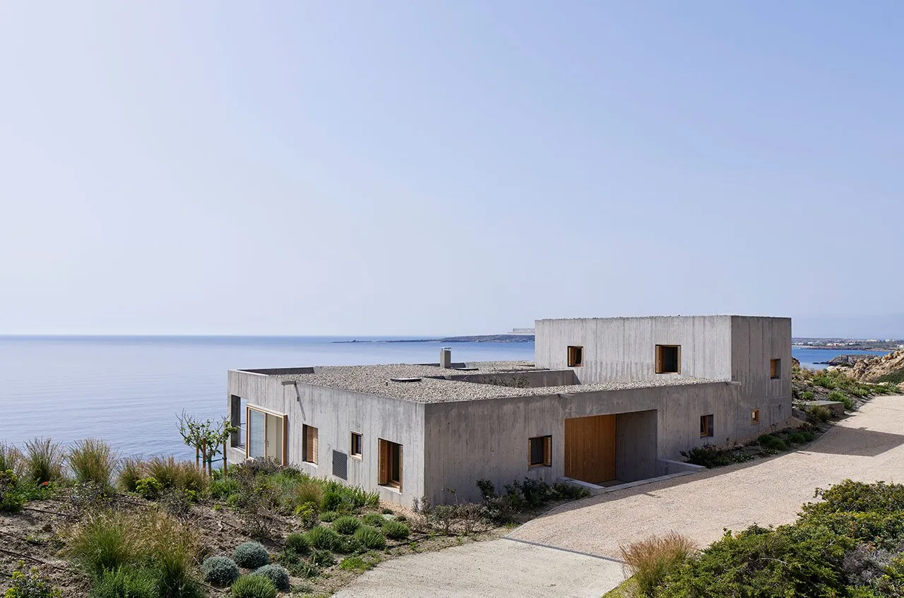 Modern, minimalist house with concrete facade overlooking the ocean.