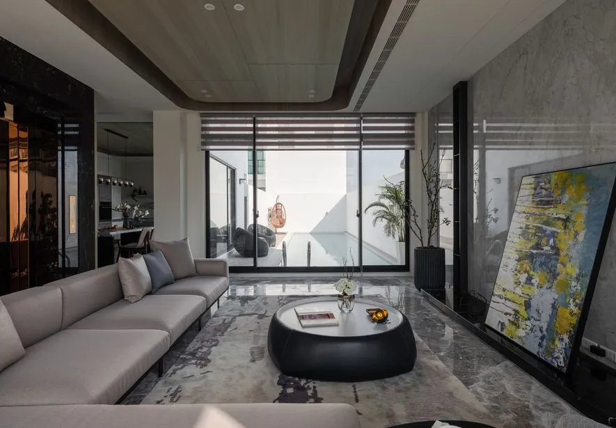 Modern living room with concrete, glass, and marble materials.