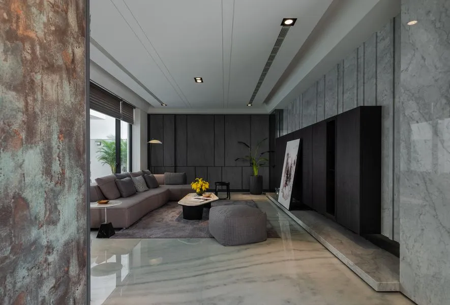 Modern living room with marble floor, concrete walls, and metal accents.