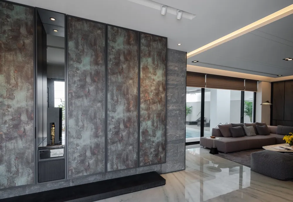 A modern living room featuring metallic panel walls and a sleek seating area.