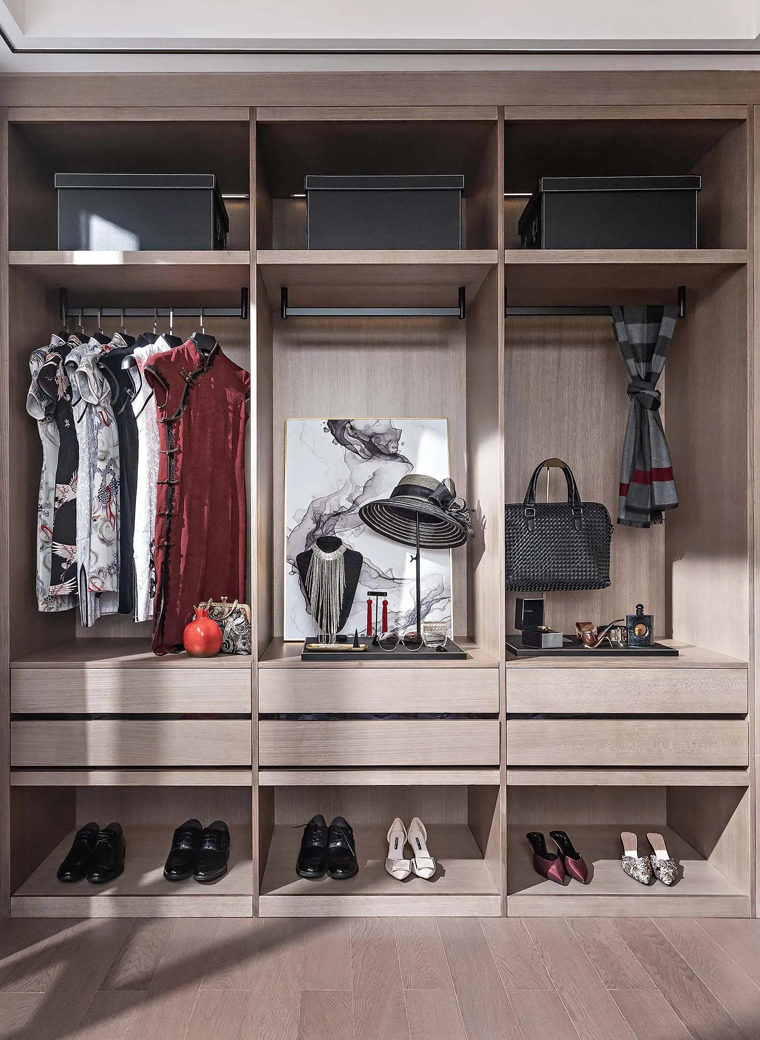 Well-organized closet space featuring wooden shelves, hanging rods, and drawers with various clothing, shoes, bags, and acces