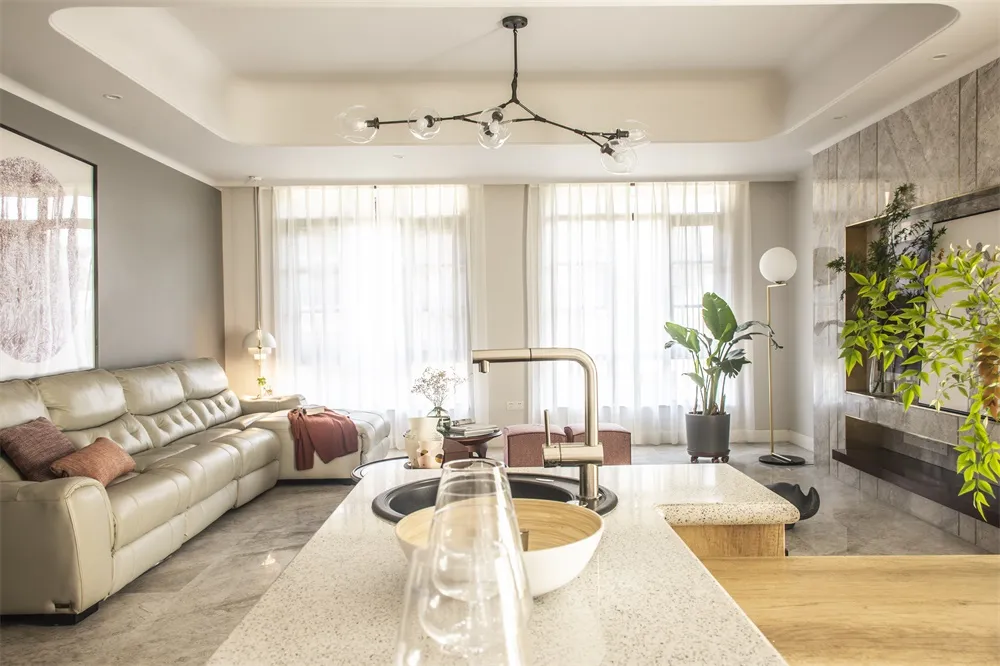 Modern living room featuring a marble and concrete combination with a cozy beige leather sofa.