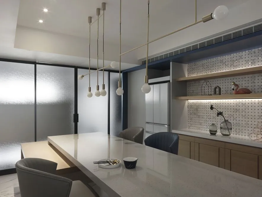 Modern kitchen with marble countertops, wooden cabinets, and glass shelves.