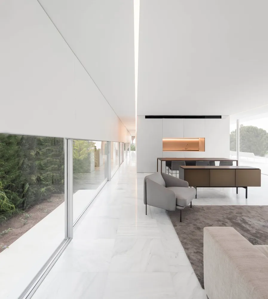 Modern residential kitchen with white marble countertops, white marble flooring, and minimalist design.