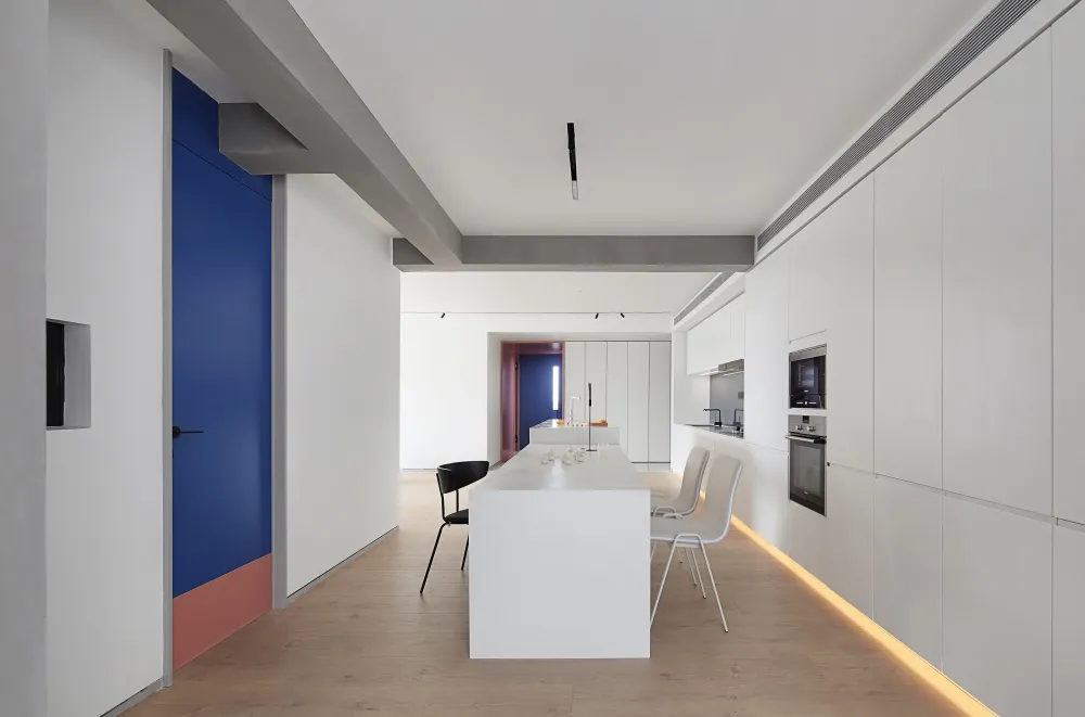A modern, minimalist kitchen with white cabinets and accents.