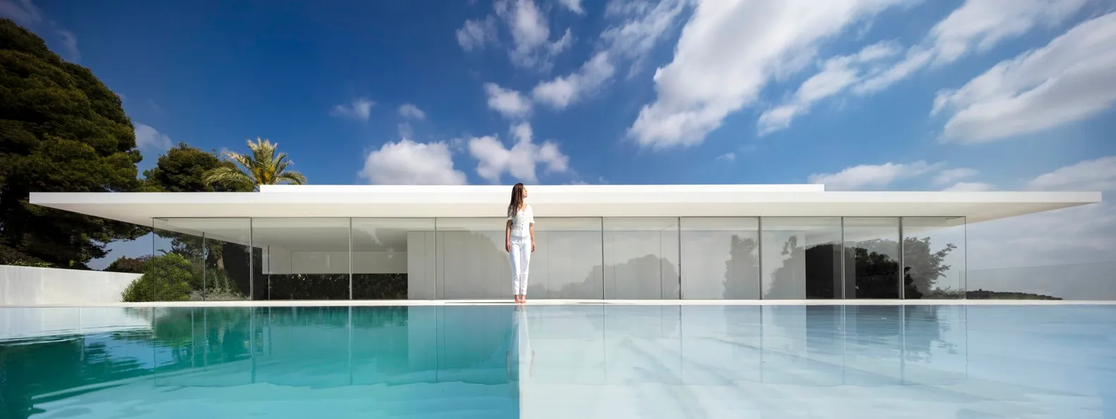 A modern house featuring extensive glass windows and a minimalist design.