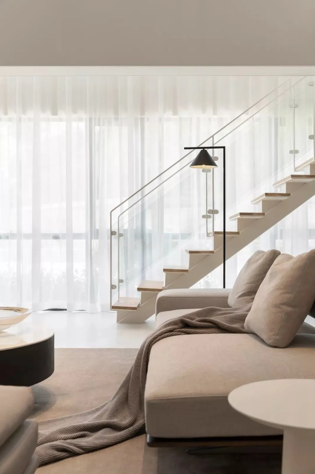 Modern living room featuring soft, neutral furnishings with a minimalist design.