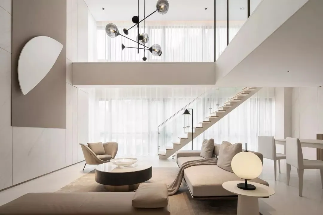 Modern minimalist living room with a neutral color palette, featuring contemporary furniture and minimal decorative elements.