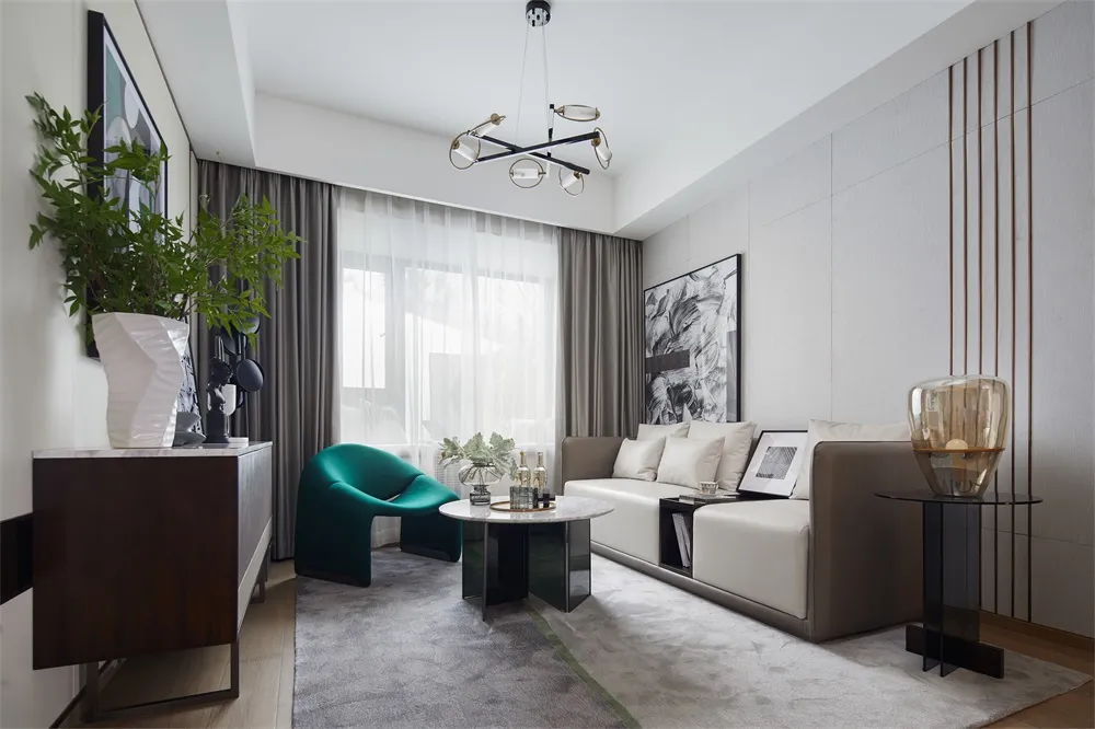 A modern minimalist living room featuring a white couch with white and green pillows, a round coffee table, and a floor-to-ce