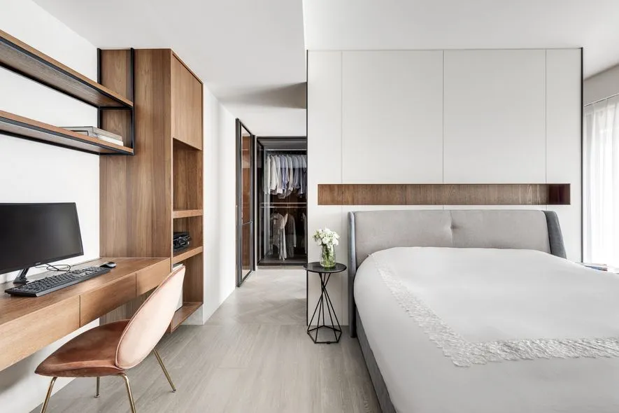 A minimalist bedroom with wooden furniture and a clean, modern design.