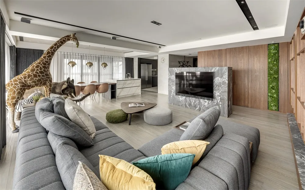 Modern, open-plan living room with a cozy seating arrangement, a stylish coffee table, and a sleek kitchen area in the backgr