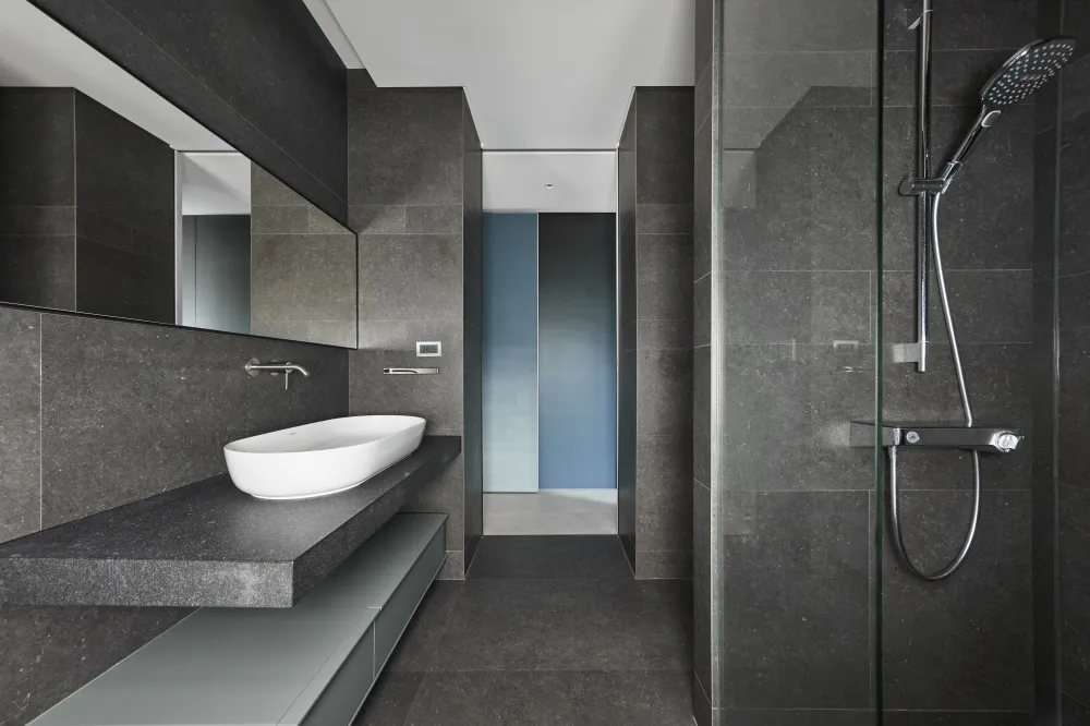 A modern bathroom with a concrete sink and floor.