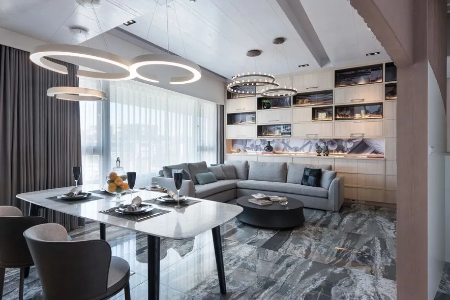Modern living room with marble floor and grey sofa.