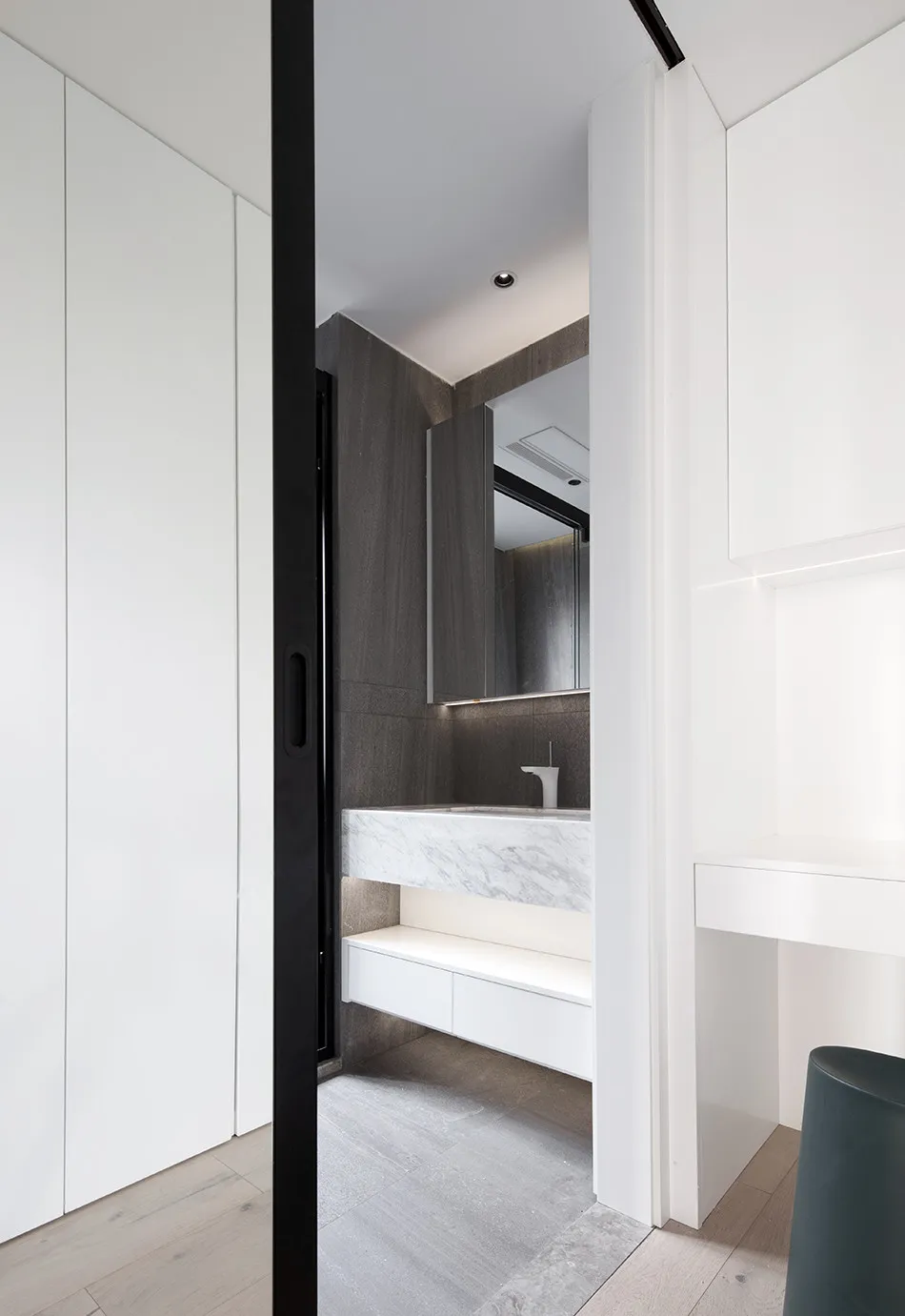 Modern bathroom features marble countertops and concrete walls for a sleek, contemporary design.