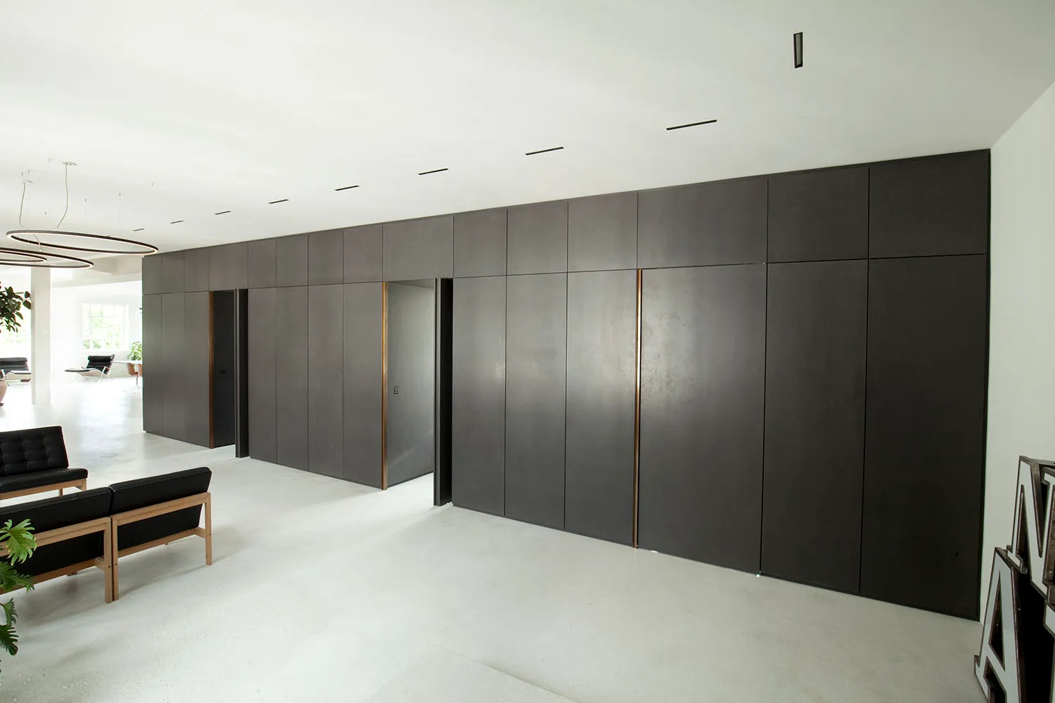 A modern minimalist living room with a concrete floor, clean lines, and sleek design elements.