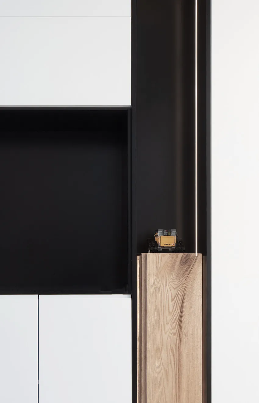 A minimalist cabinet with white, black, and wooden elements.