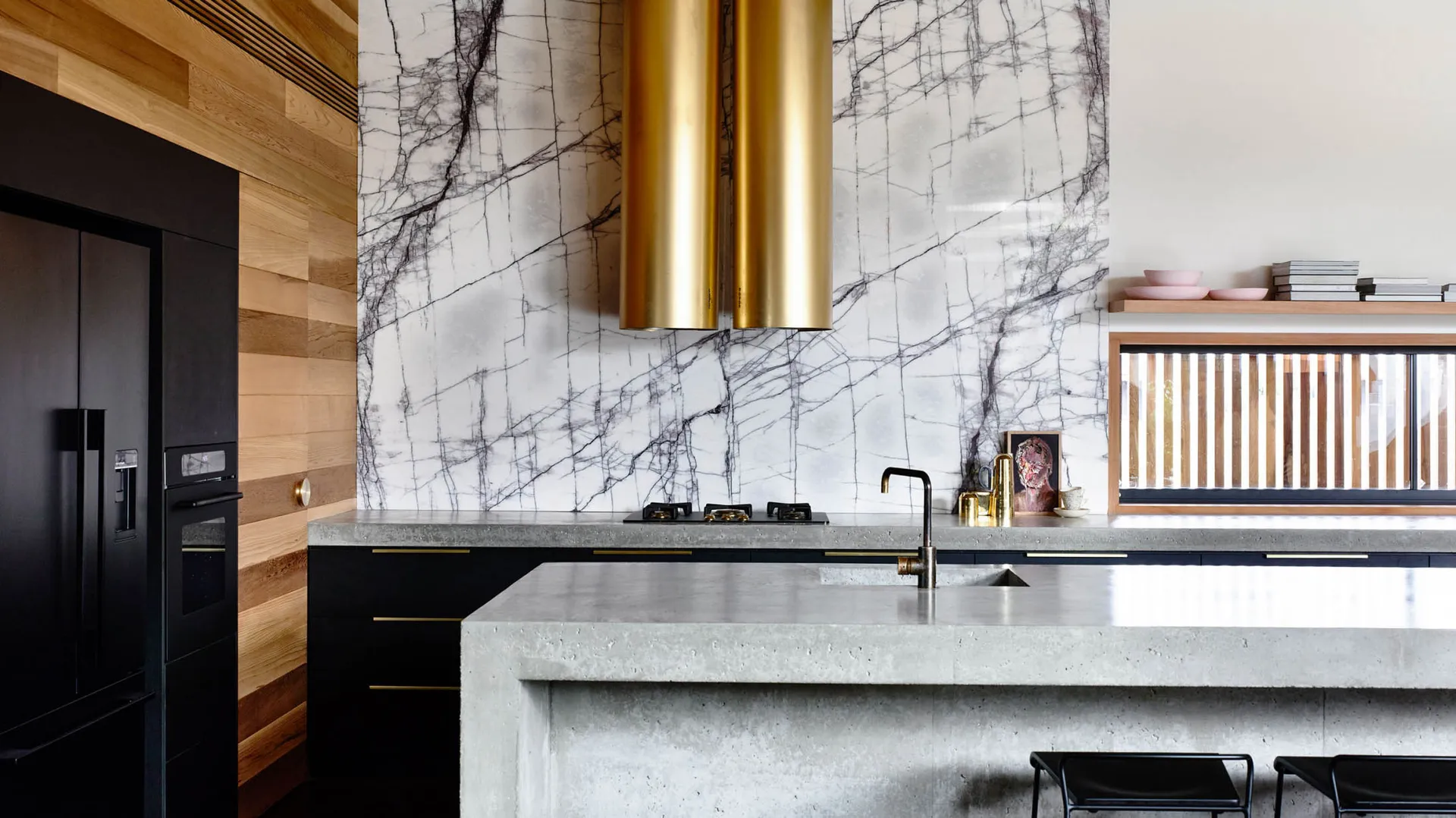 Modern kitchen with concrete countertops, minimalist design, and marble backsplash.
