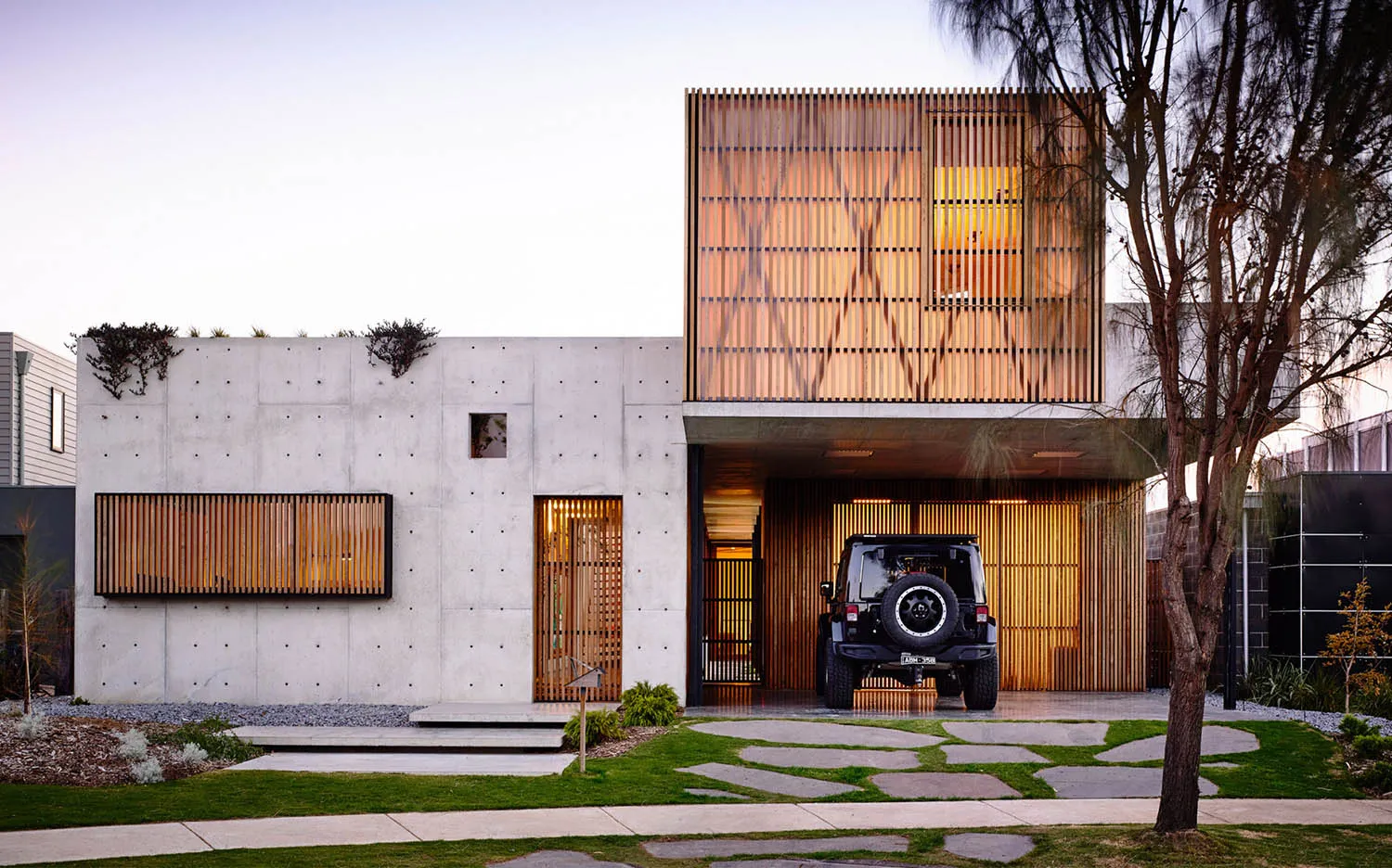 A modern, minimalist house with a concrete facade, wooden accents, and glass windows and doors.,
