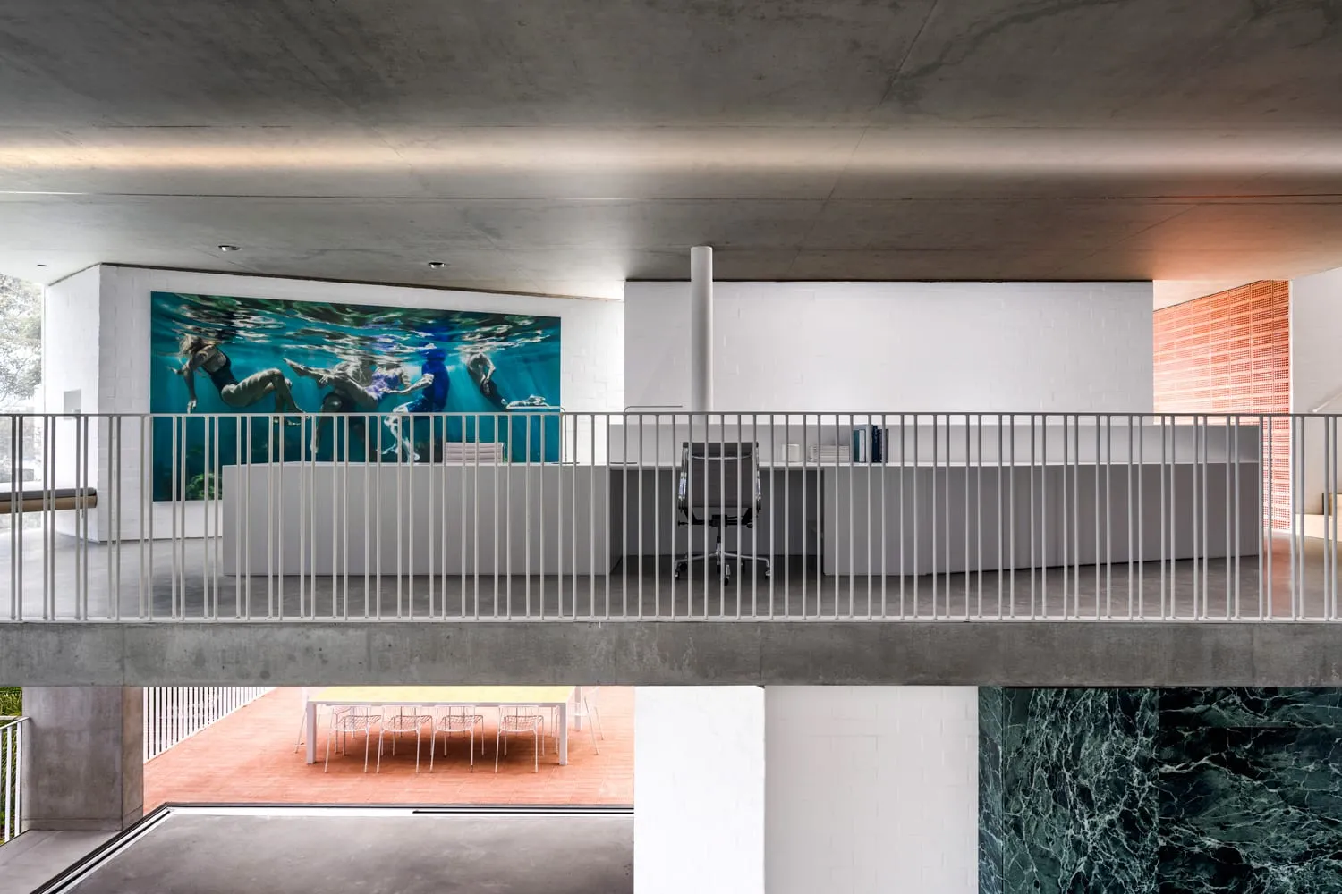 An office space featuring minimalist design with concrete and glass materials.