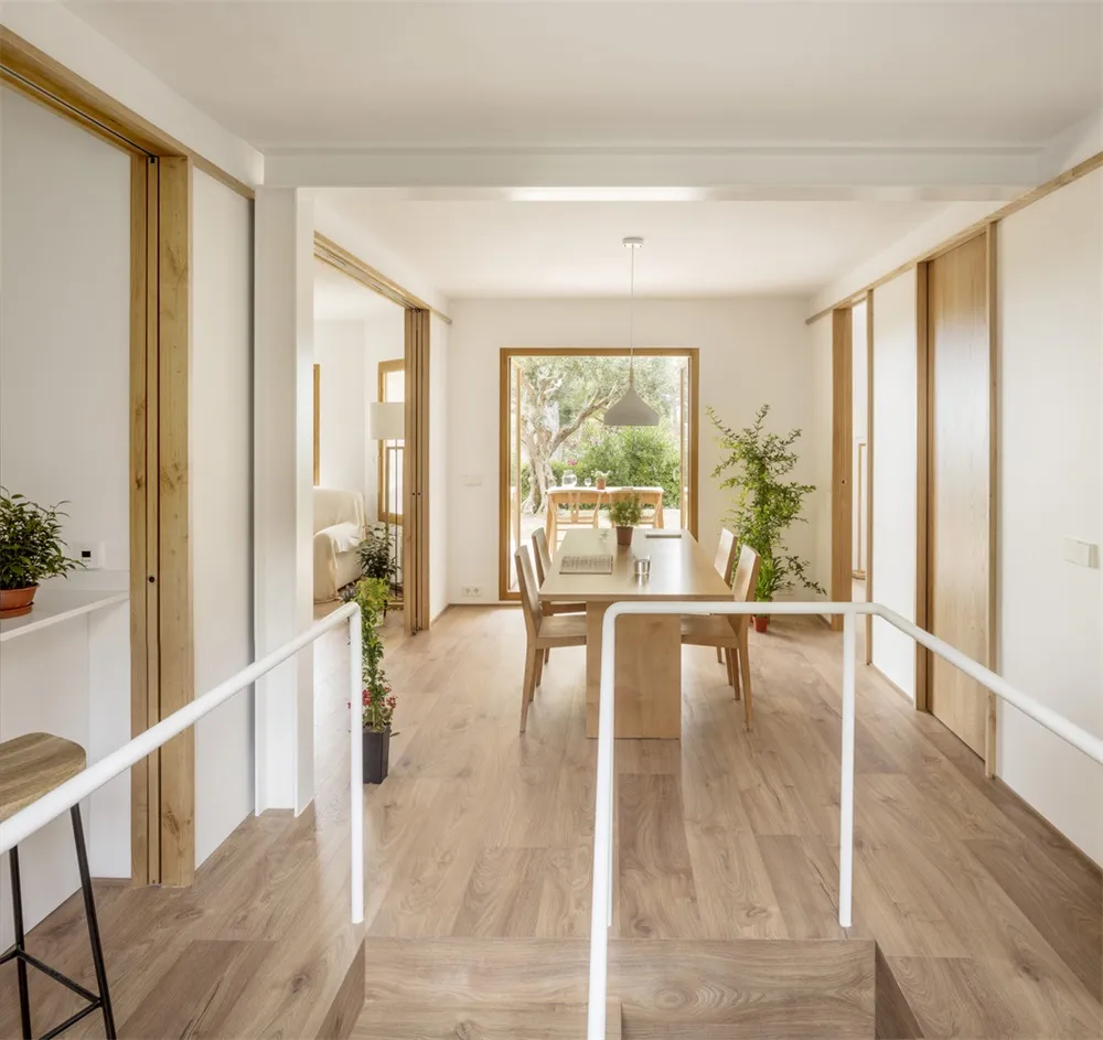 Modern minimalist living space with white walls and wooden flooring.