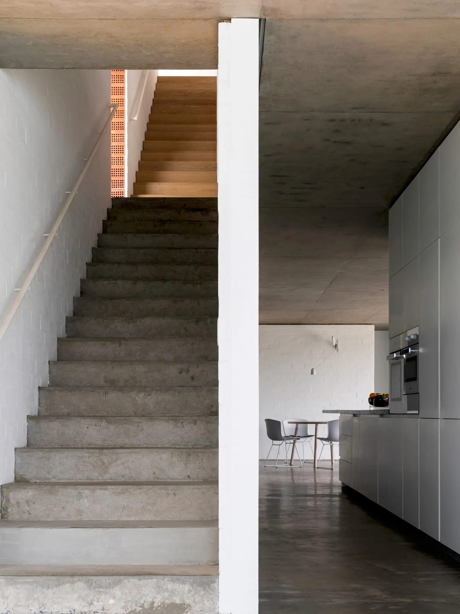 A modern living room with concrete walls and floors, featuring clean lines and minimalist design.