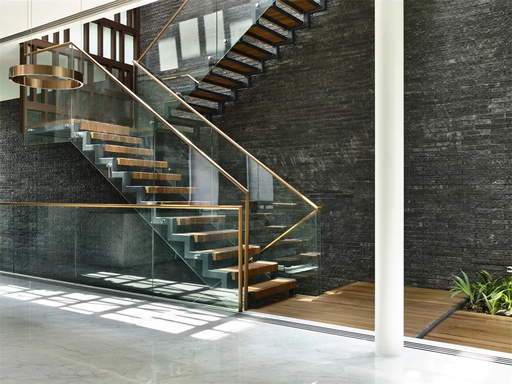 Modern staircase with glass railings and metallic steps.