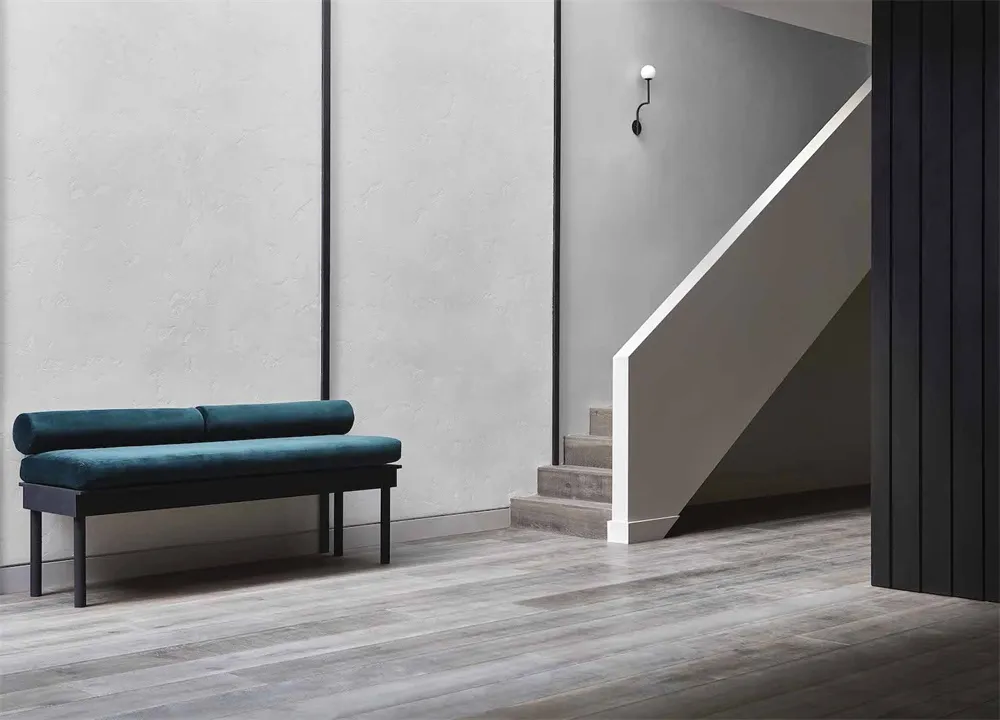 Modern minimalist interior design featuring a wooden floor and a turquoise cushioned bench.