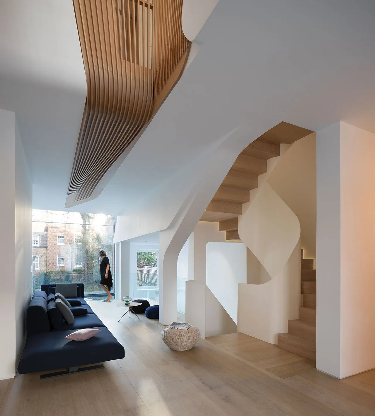 A modern residential interior featuring concrete stairs, wooden elements, and glass windows.
